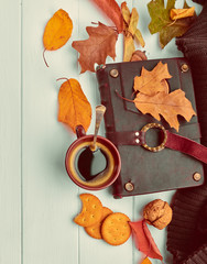 Cup coffee with book in leather binding autumn dry leaf and warm