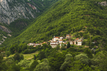 Beautiful mountain village on a green mountain slope. Village Jance (Јанче) in Macedonia. The village is old and picturesque. There's a mountain valley on the left.