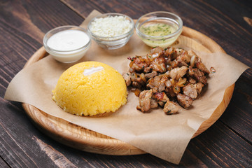 Traditional moldavian meal - hominy with fried meat, white cheese and sauce