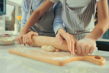Family hobby. Close up of mothers and childish hands preparing bakery rolling out dough