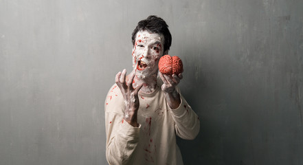 Terrorific zombie eating a brain.  Halloween holidays