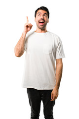 Young man with white shirt intending to realizes the solution while lifting a finger up on isolated white background