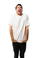 Fototapeta premium Young man with white shirt shouting to the front with mouth wide open on isolated white background