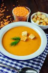 Lentil soup, white plate, blue checkered napkin, wooden background, bean, home cooking