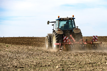 tracteur agricole avec le déchaumeur en action sur le champ