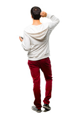 Full body of Man with glasses and listening music on back position looking back while scratching head on white background