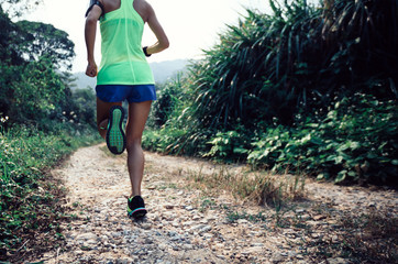 young fitness woman trail runner running on forest
