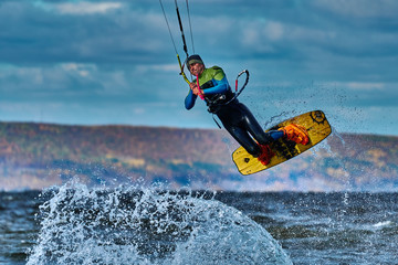 Naklejka premium A male kiter jumps over a large lake. Close-up.
