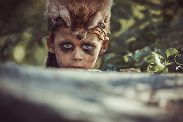 Caveman, manly boy hunting outdoors. Prehistoric tribal boy outdoors on nature. Young shaggy and...