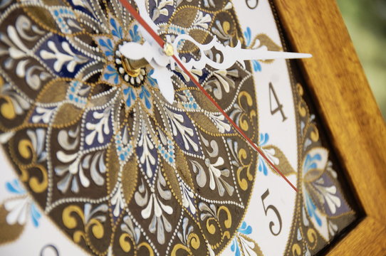 brown square hand-painted watch with contour acrylic paints in the technique point to point, with a geometric pattern in the form of a mandala, black numerals and white arrows