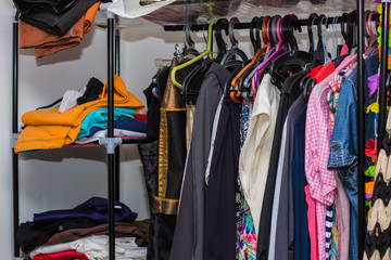 Wardrobe with messy organized clothes.