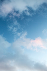 blue sky with fluffy clouds and a little pink