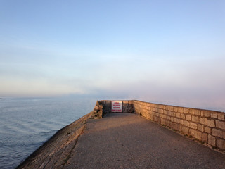 View on sea, path and foggy horizon during early winter morning 