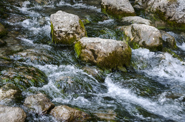 Naklejka na ściany i meble Large stones in a mountain river