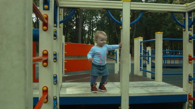 Little girl running around the playground. Walk in the park. Family vacation.