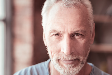 Optimism. Close up of elderly man expressing kindness while looking at you and having pleasant mood