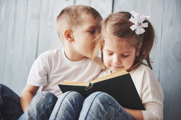 Ready to big travel. Happy little girl and boy reading interesting book carrying a big briefcase and smiling. Travel, freedom and imagination concept