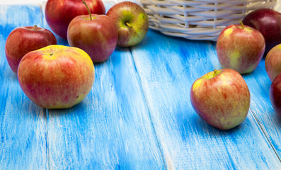 Apples on a blue wooden background. Red and yellow farm apples.