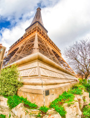 Wide angle upward view of Tour Eiffel as seen from surrounding gardens
