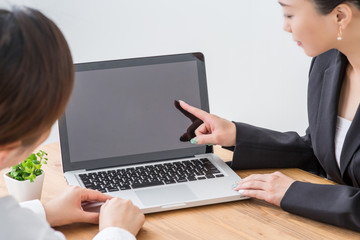 PCを見ながら会議する女性