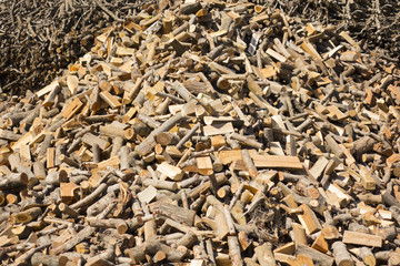Punctured firewood in a pile against the background of a wood-burning barn