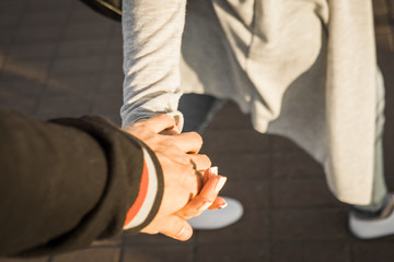 The guy with the girl go down the street holding hands.