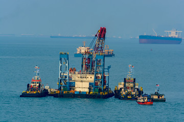 Grab Dredger - revolving crane, fitted with a grab, placed on a hopper vessel or pontoon. Singapore Strait.