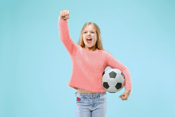 Fan sport girl holding soccer ball isolated on blue studio background