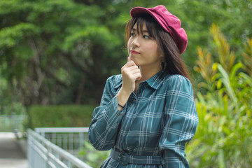 attractive asian woman thinking on garden background.