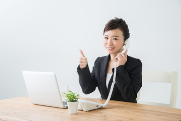 電話と笑顔のビジネスウーマン