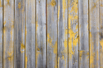 wooden background, old wooden wall with remains of yellow paint
