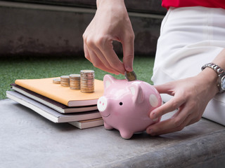 Woman Putting Coin In Piggy Bank.;