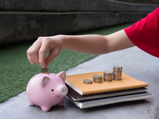 Woman Putting Coin In Piggy Bank.;
