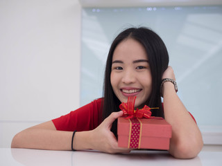 Portrait of a young woman with a red giftbox
