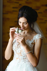 gorgeous bride holding boutonniere, beautiful woman getting ready for wedding day, holding flowers veil. sensual moment. boudoir. morning of the bride