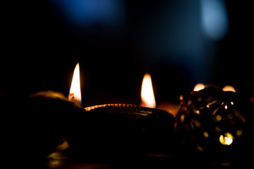 Beautiful diwali diyas at night with flowers, lighting series and gifts, moody background