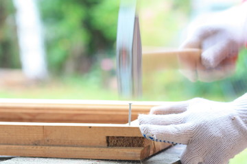 Carpenter hammer nail into a wooden frame