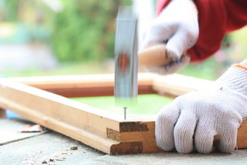 Carpenter hammer nail into a wooden frame