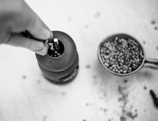 vintage pepper mill and peppercorns on wooden background