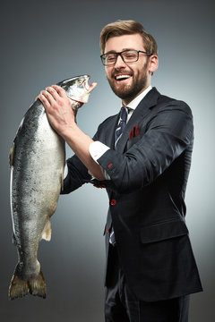 A man in a business suit with fresh salmon i