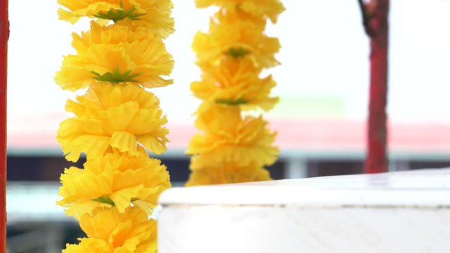 ein Blumen Arrangement weht leicht im Wind vor einem Tempel in Thailand