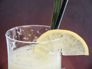 A slice of lemon on a glass of drink with sugar crystals
