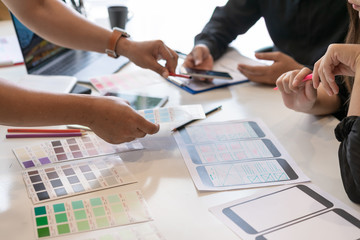 Creative designer choosing color samples for mobile responsive website development with UI/UX....