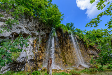 PLITVICE NATIONAL PARK, CROATIA - JUNE 8, 2018: Tourist group by the lake in the Plitvice Lakes National Park.
