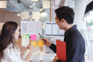 Creative ux designer team developing wireframe sketch layout design mockup on smartphone screen.