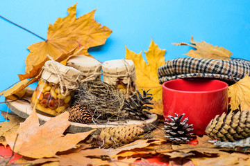 Natural homemade treats autumn season keep healthy. Set three honey natural sweets in jars and mug of tea background covered fallen leaves. Autumnal beverage with homemade natural sweets