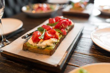 bruschetta with tomatos served on wooden stand