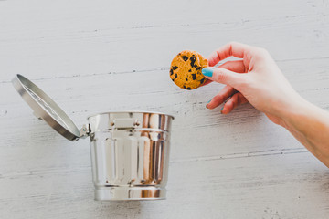 hand throwing website cookie going into a trash can