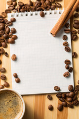 Blank notepad for copy space with coffee cup and spices on wooden board