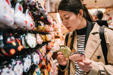 a lovely female tourist choosing coin purses